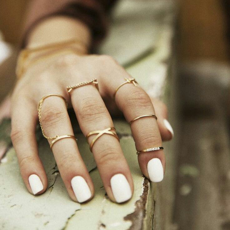 Stack of minimalist rings, white color nails