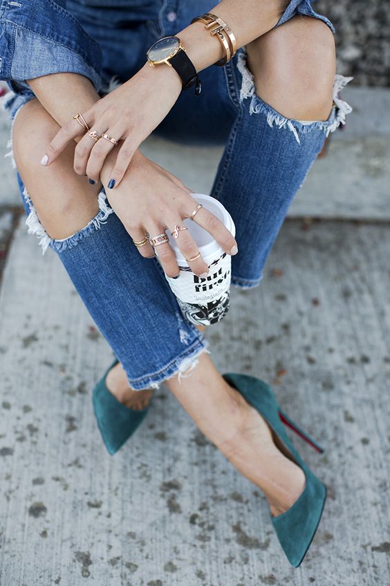 Ripped denim jeans, stacked minimalist rings