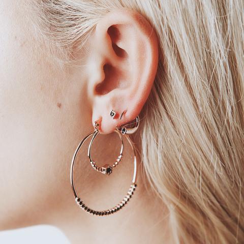 Stack of rose gold hoop earrings